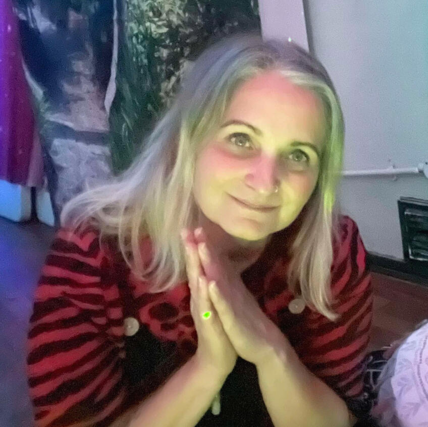 Portrait of Becky from Golden Light Healing with hands in prayer and a calm welcoming expression.